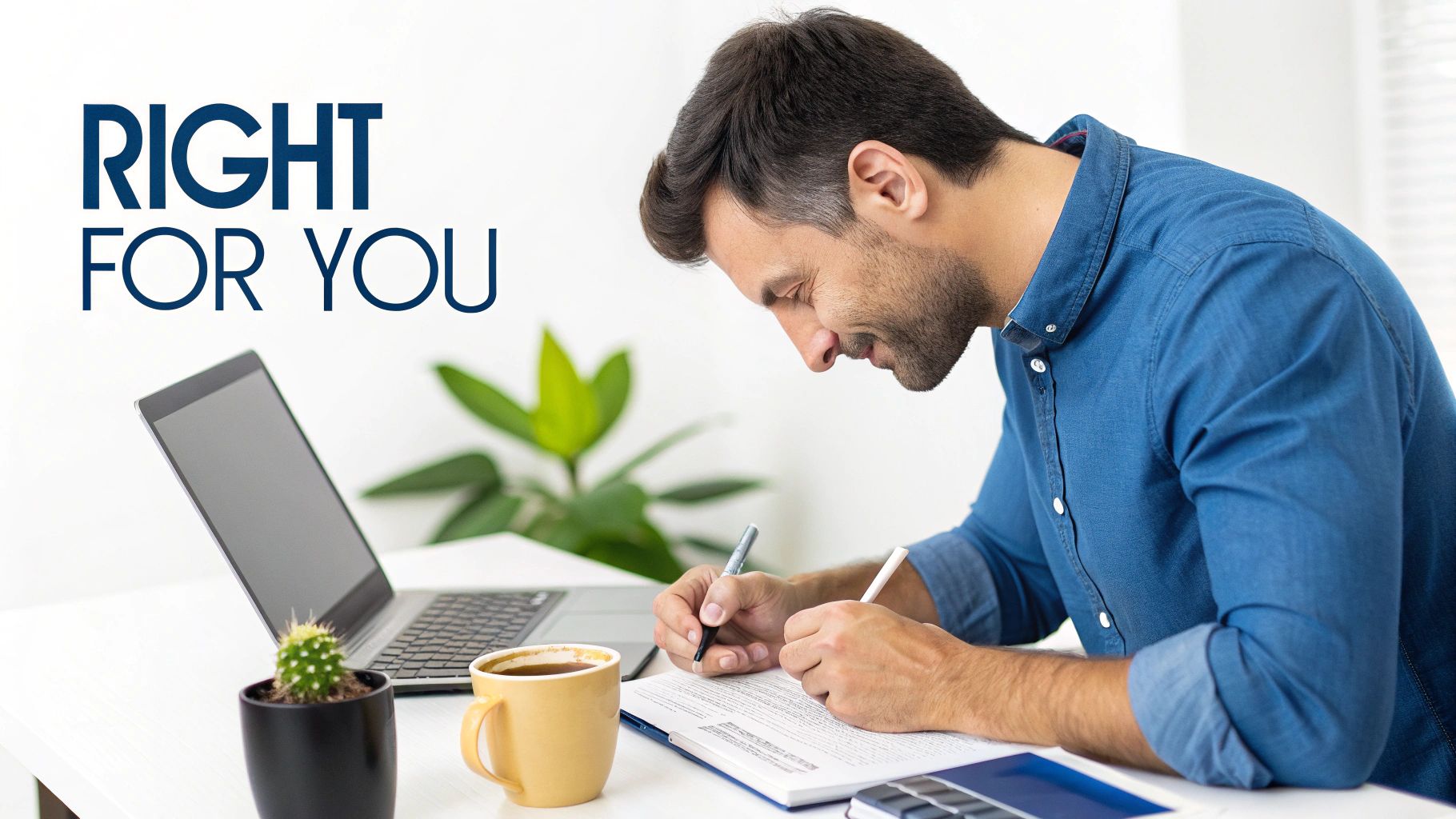 A man at a desk writing on a document with a laptop, coffee, and cactus nearby.